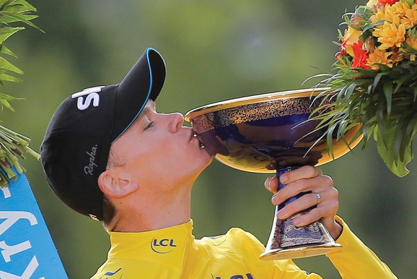 FILE - This is a Sunday, July 26, 2015 file photo of race winner Britain's Chris Froome kisses the trophy as he stands on the podium at the end of the Tour de France cycling race in Paris, France. Froome Elba was awarded an OBE (Officer of the Order of the British Empire) in the Queen's 2016 New Year's Honours List.( AP Photo/Laurent Cipriani, File)